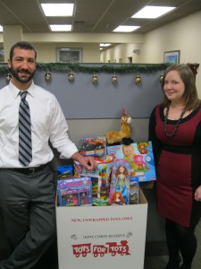 Domenick DelRosso (left) and Mistie Knapp (right) with gifts gathered by the Judelson, Giordano & Siegel staff and partners for the annual Toys for Tots campaign.