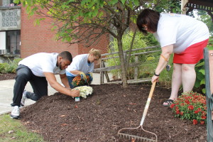 United Way loaned executives Kyle Richardson, left, Linda Shuback and Haydee Furman work on mulching and planting activities.