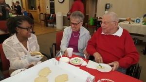 Anjoule LeLaMartin of the Newburgh School District talks about cookie frosting options with Glen Arden residents Esther and Martin Schwager during Junior Leadership Orange’s recent visit to Glen Arden. 