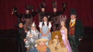 Some of the cast of the George F. Baker High School’s production of “The Wizard of Oz.” In the back row, “trees” Tara Odell, left, Taylor Spivak and Madeline Doyle. Middle row: Rosalie Rodriquez, left, as the Wicked Witch;  Rachel Levinsky, as the Tin Man; Daria Fatemi, as Dorothy; Heidi Willins as Glenda the Good Witch; and Assistant Principal  Eric Sorenson as the Wizard of Oz. Bottom row: Matt Willins, left, as the Scarecrow;  and John Castricone as the Cowardly Lion. 